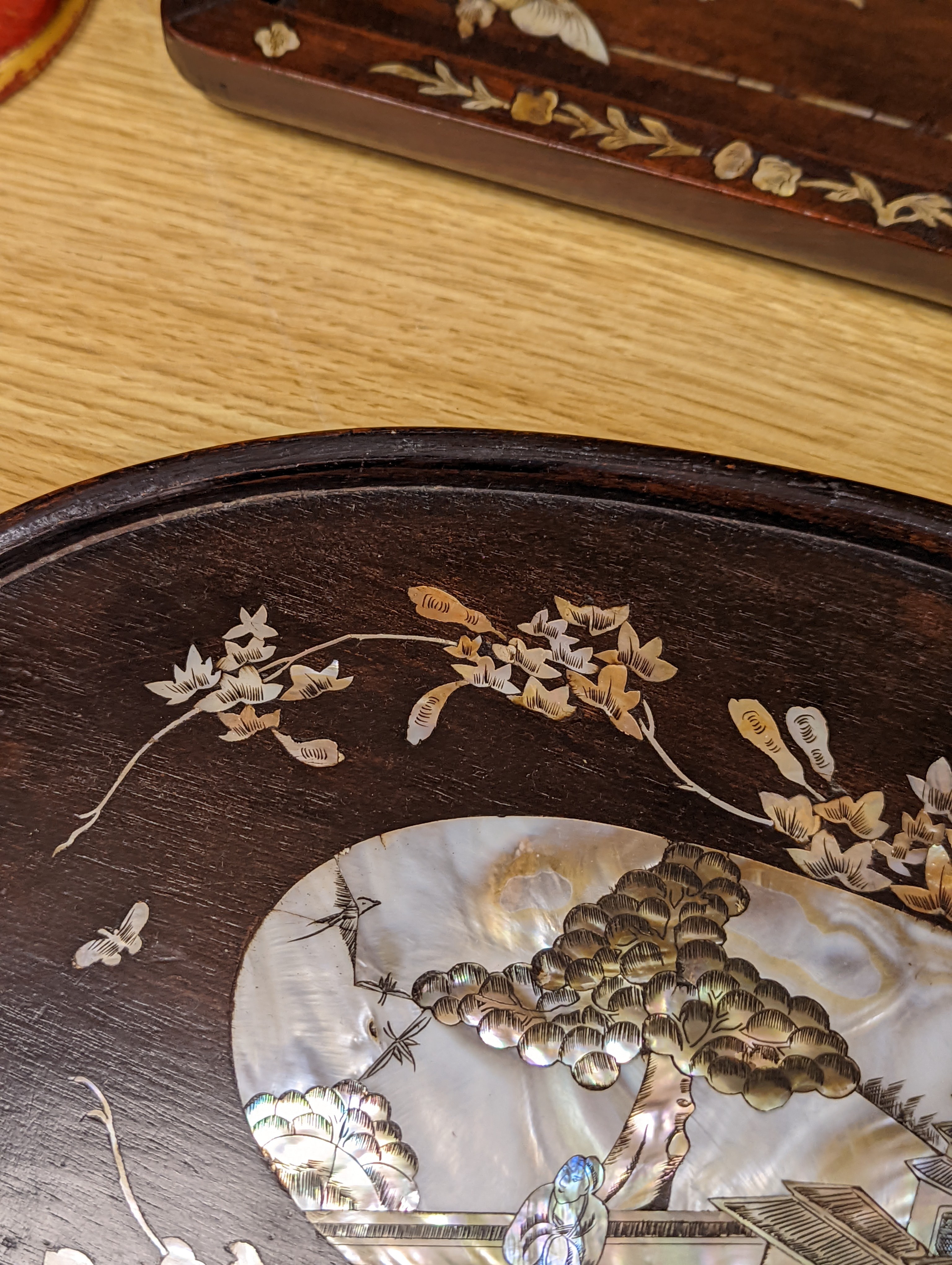 Two Chinese mother of pearl inlaid hongmu trays, the rectangular example with birds and insects amid flowers and the smaller oval example with a pavilion in a landscape within floral sprays 55x34cm
